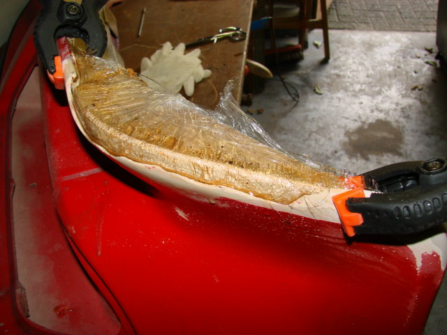 Een houten malletje gewikkeld in keukenfolie om de glasvezel in vorm te houden